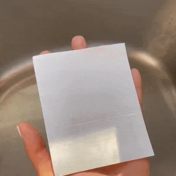 Feuille de lessive GREEN DETER tenue à la main près de l’eau